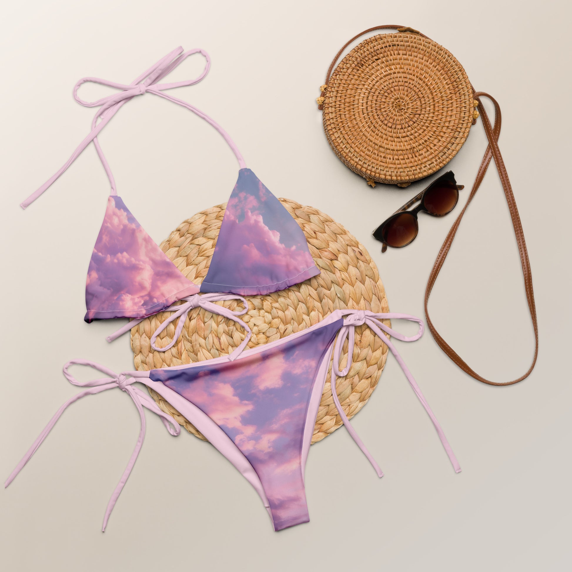 cloudy dreamy two piece string bikini, purple pink clouds, next to sunglasses