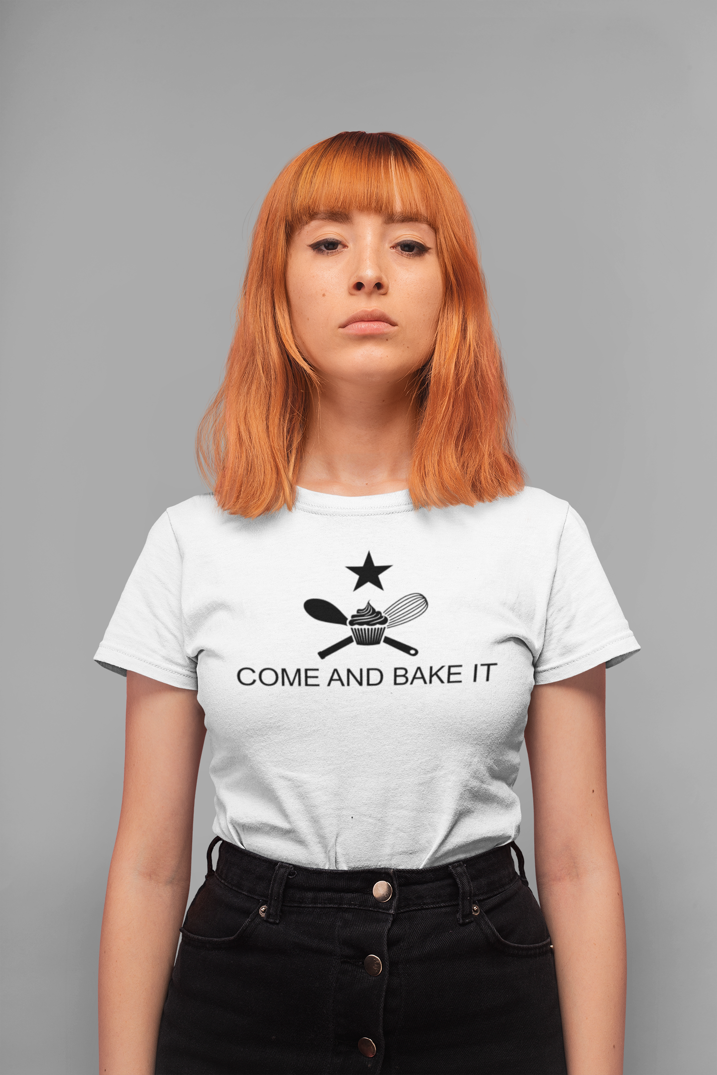 woman wearing white shirt with text "come and bake it" with a cupcake, whisk, and mixing spoon