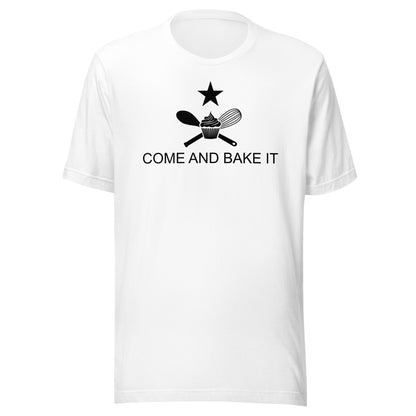 white shirt with text "come and bake it" with a cupcake, whisk, mixing spoon. and star design